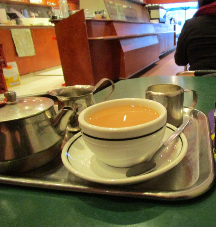 Photo of poured tea on a metal tray in a city coffee shop